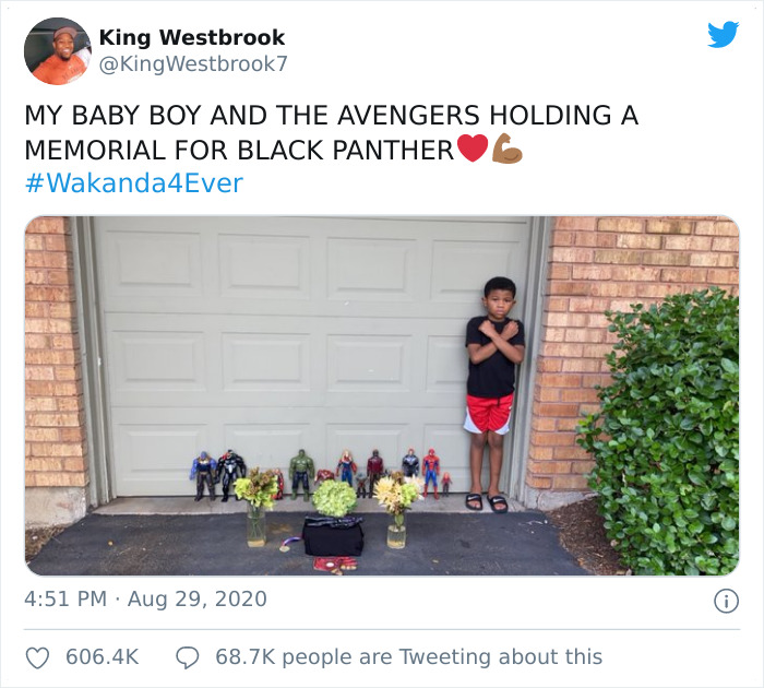 Boy standing next to a Black Panther action figure memorial with flowers honoring the late Black Panther hero.