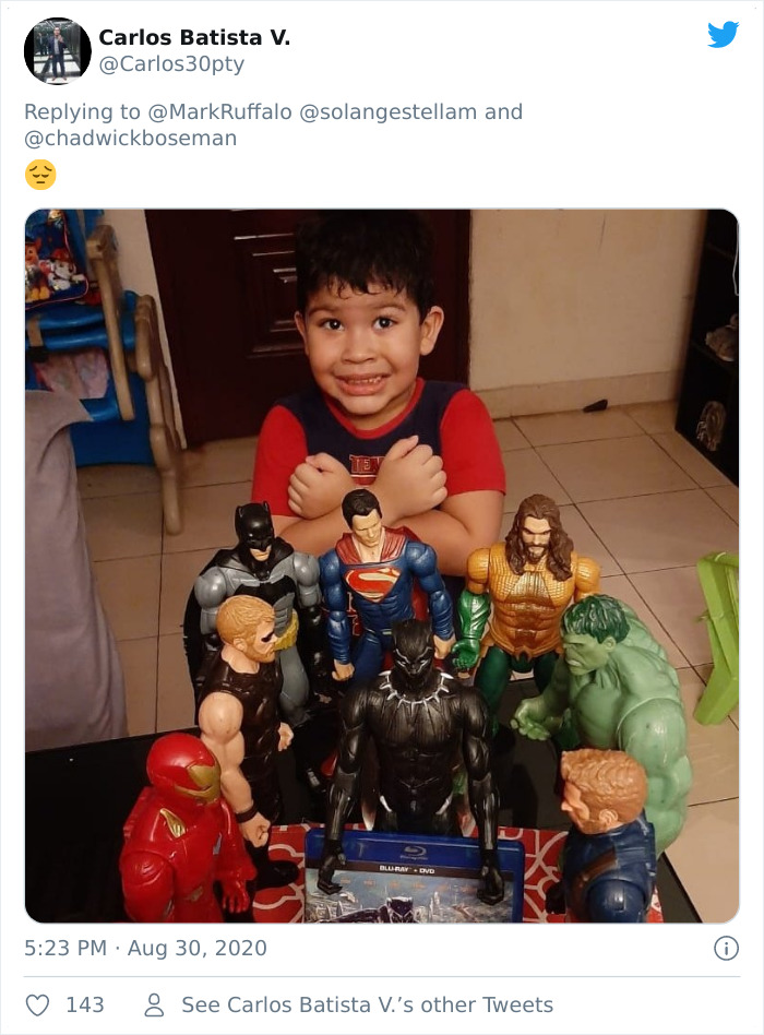 Young boy with superhero action figures including Black Panther in a heartfelt tribute memorial by kids honoring late Black Panther.