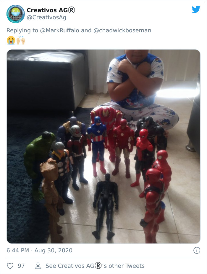 Child sitting with Black Panther action figure memorial surrounded by Marvel superhero toys honoring the late Black Panther.