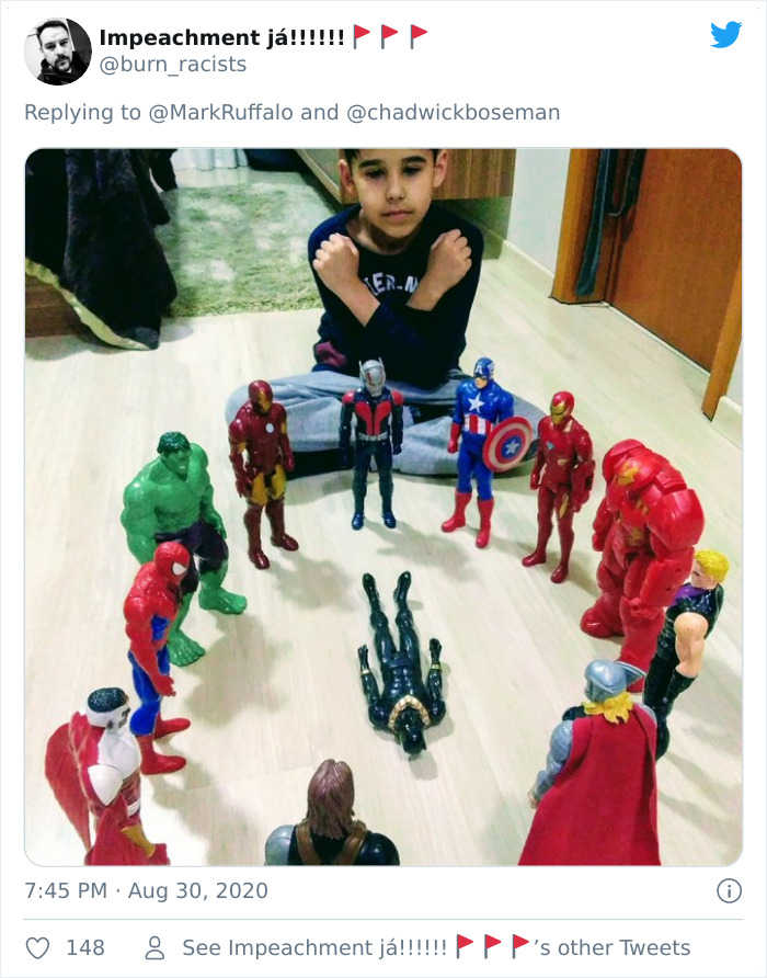 Child honoring late Black Panther with action figure memorial arranged in a circle on the floor showing respect and remembrance.