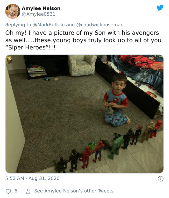 Young boy kneeling by a line of action figures honoring late Black Panther in a heartfelt memorial display.