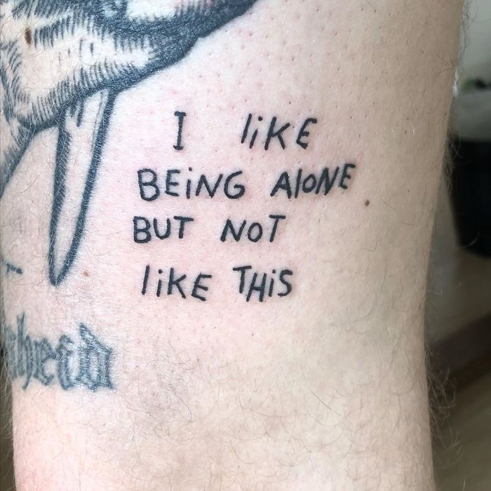 Creative Covid-19 tattoo with text "I like being alone but not like this" on skin.