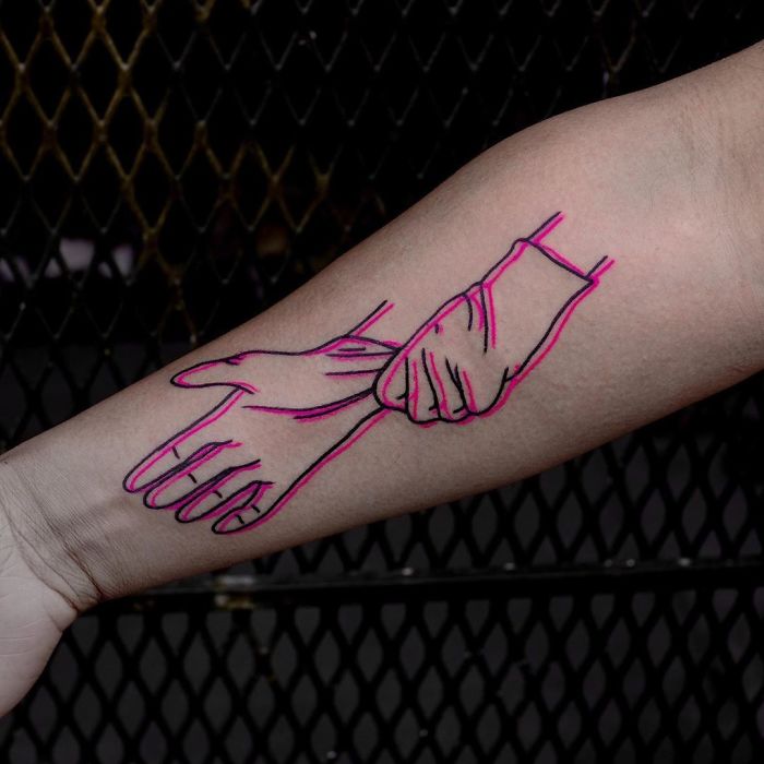 Creative Covid-19 tattoo of outlined gloved hands on forearm.