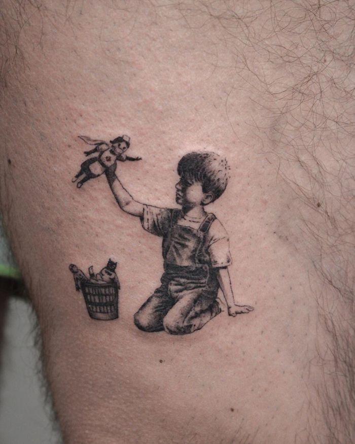 Creative Covid-19 tattoo of a child with a superhero doll, symbolizing hope during the pandemic.