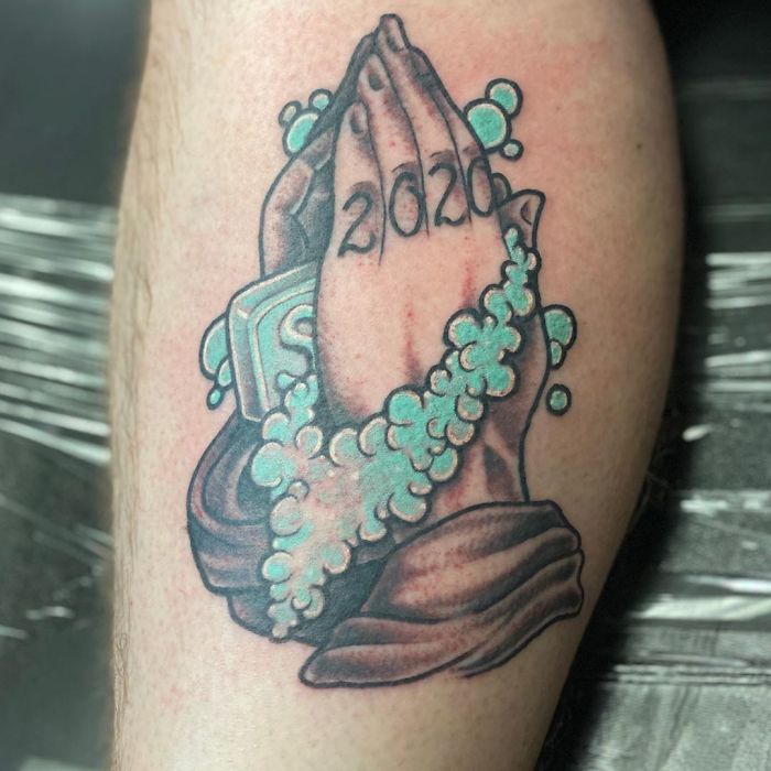 Creative Covid-19 tattoo of praying hands with bubbles and the year 2020.