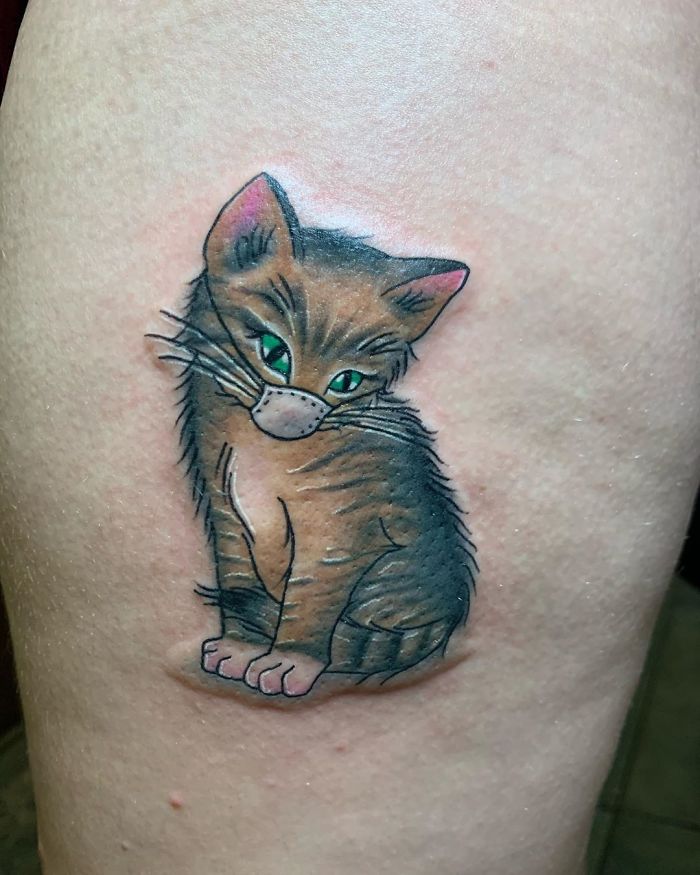 Tattoo of a tabby cat wearing a mask, a creative Covid-19 design on skin.