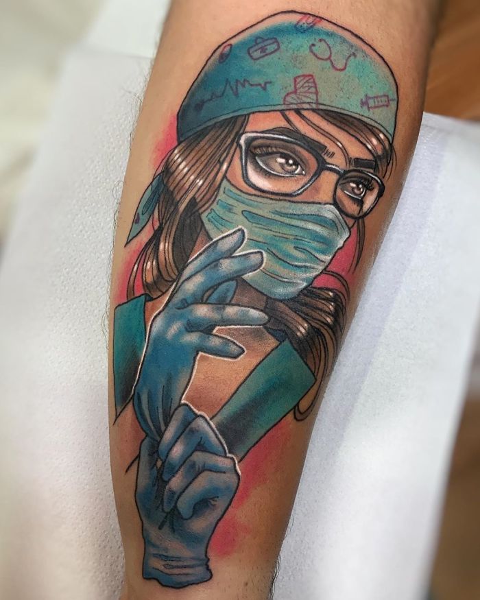Creative Covid-19 tattoo of a nurse wearing a mask, glasses, and gloves on an arm.