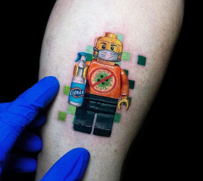 Creative Covid-19 tattoo of a Lego figure wearing a mask, holding Clorox, on an arm.