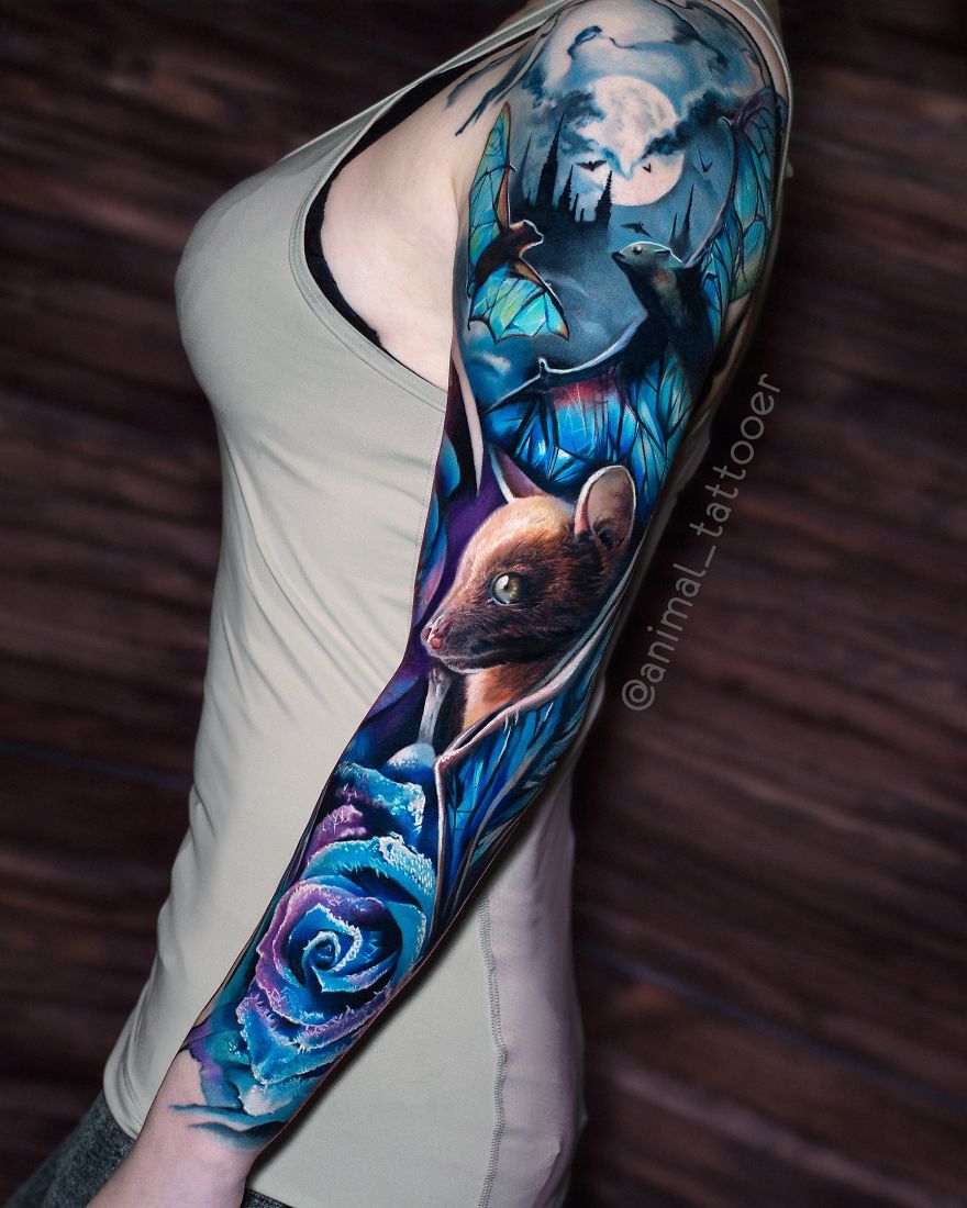 Colorful animal tattoo featuring a vibrant design of a mouse and blue rose on a person's arm.