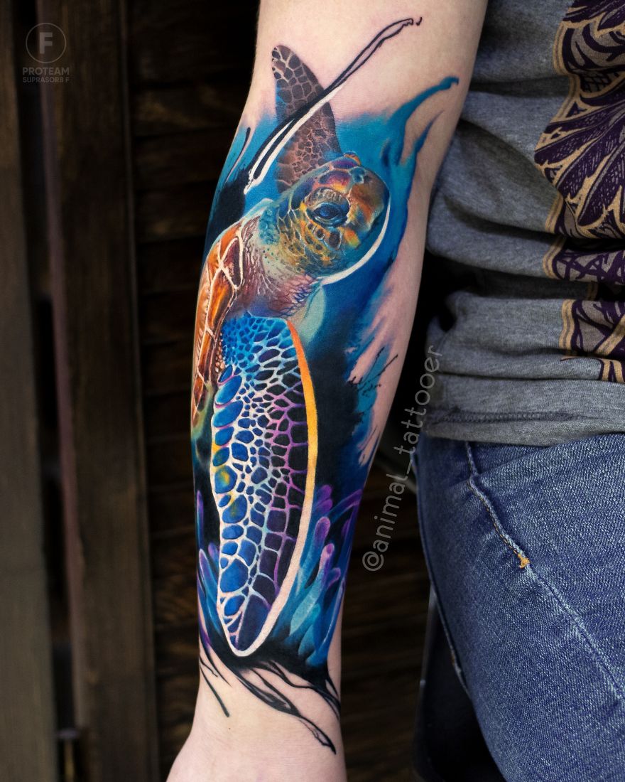 Colorful and bright animal tattoo of a sea turtle on a forearm, featuring vivid blues and oranges.