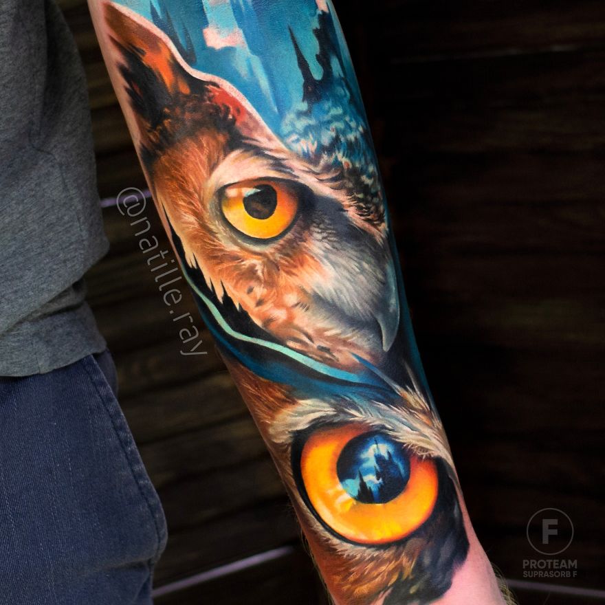 Colorful animal tattoo of an owl with bright eyes on a person's forearm.