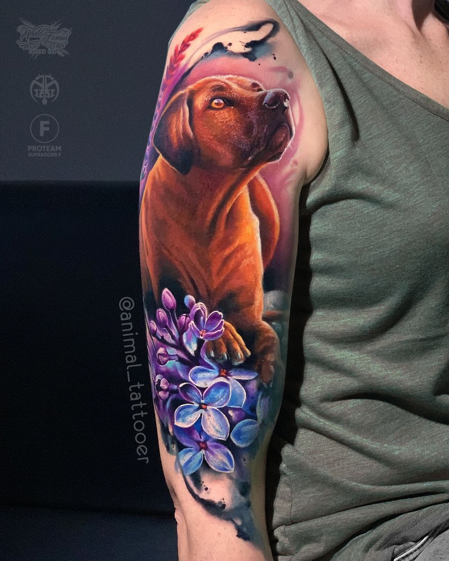 Colorful and bright animal tattoo of a dog with vibrant purple flowers on a person's arm.