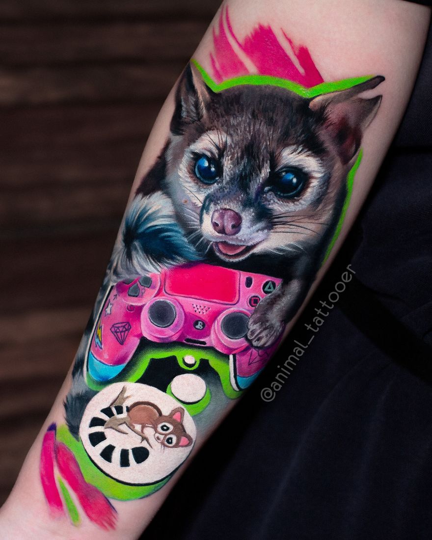 Colorful and bright animal tattoo featuring a sugar glider with a vivid pink game controller on an arm.