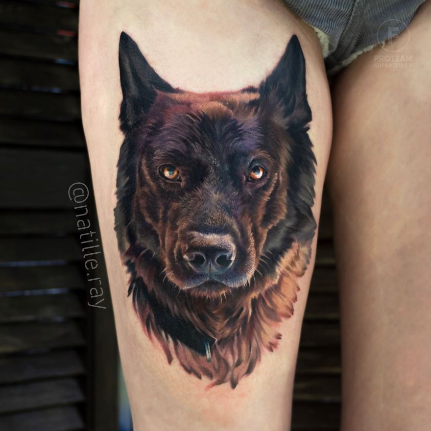 Colorful animal tattoo of a dog's face on a person's thigh, showcasing detailed artistry and vibrant tones.