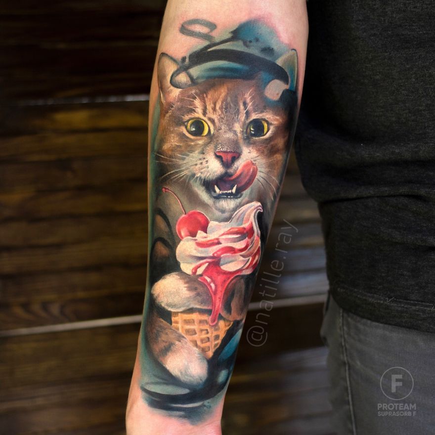 Colorful cat tattoo with a mischievous expression, holding ice cream, on a person's forearm.