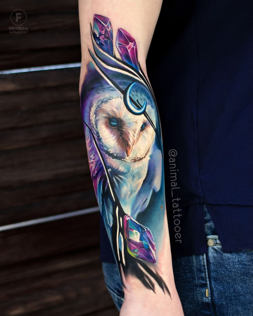 Colorful and bright animal tattoo of an owl on a person's forearm.