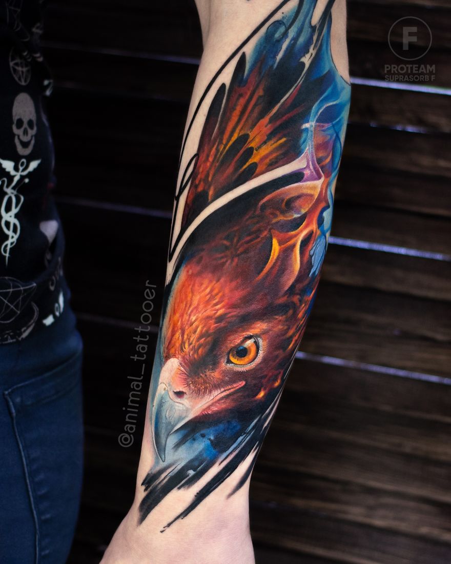 Colorful and bright animal tattoo of a bird on a person's forearm, showcasing vivid orange and blue hues.