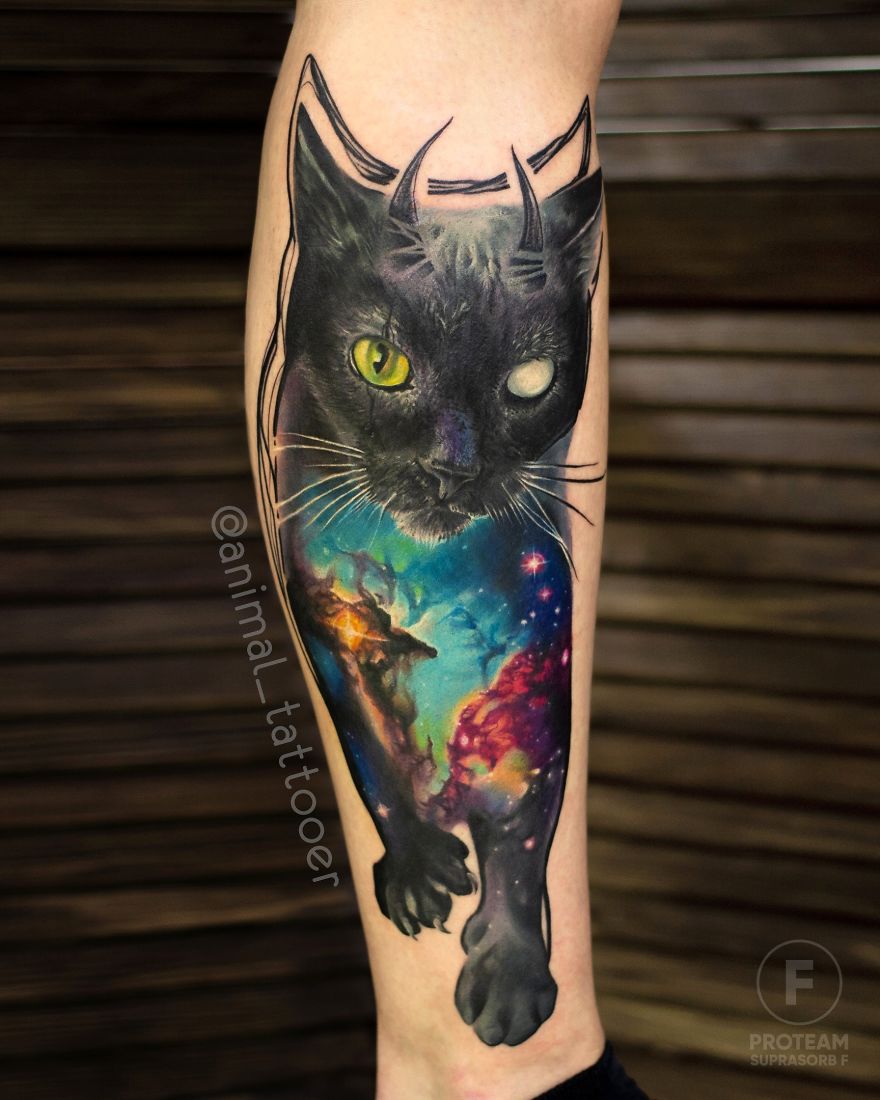 Colorful and bright animal tattoo of a black cat with a cosmic design on a person's leg.