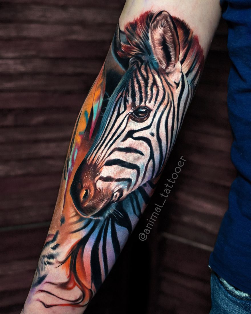 Colorful zebra tattoo on arm, showcasing bright animal artwork.