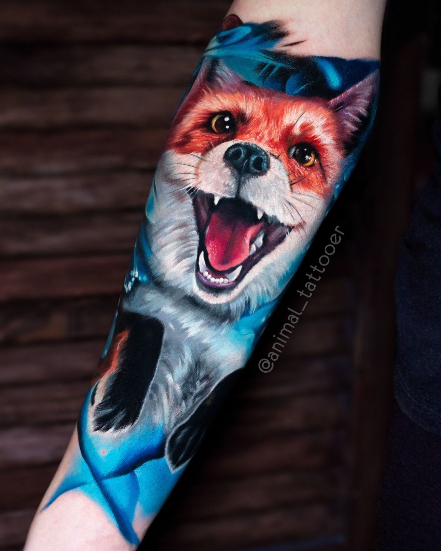 Colorful and bright animal tattoo of a vibrant fox on a forearm.