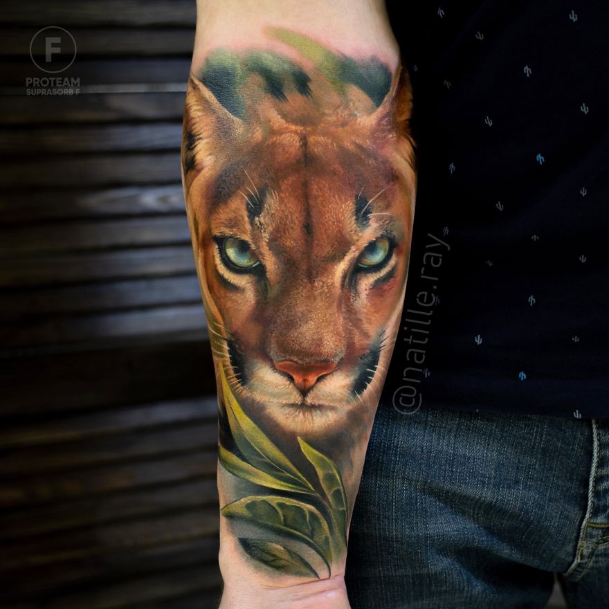 Colorful animal tattoo of a feline face on forearm, featuring vibrant details and shading.