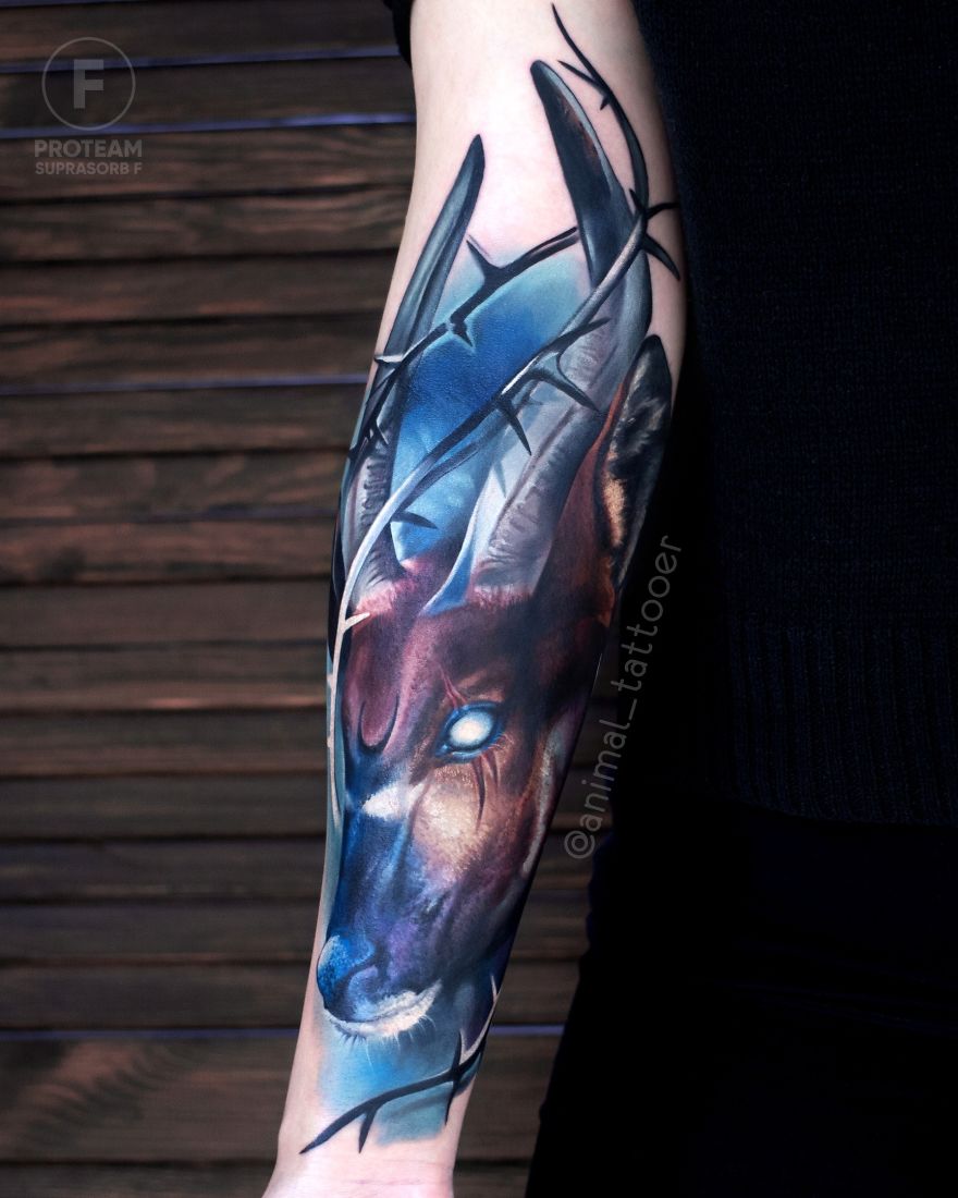 Colorful and bright animal tattoo depicting a stylized deer on a person's forearm.