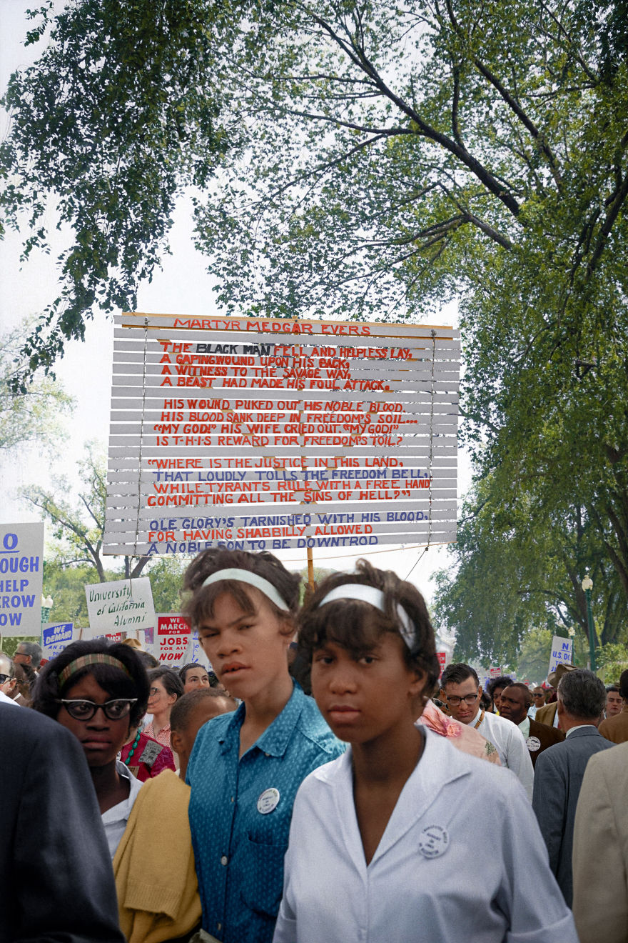 Young Women With Signs Raised Behind Them At The March On Washington