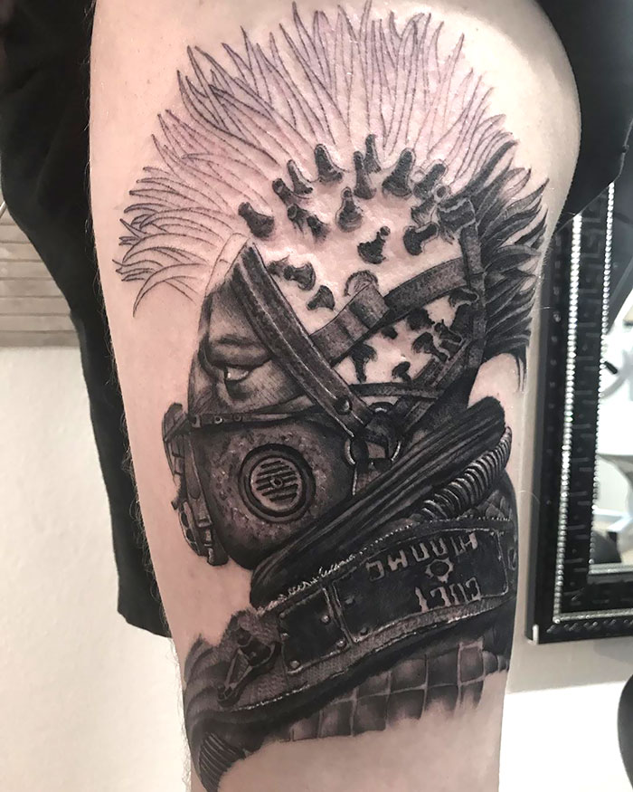 Creative Covid-19 tattoo featuring a detailed design of a person wearing a gas mask and a coronavirus-theme mohawk.