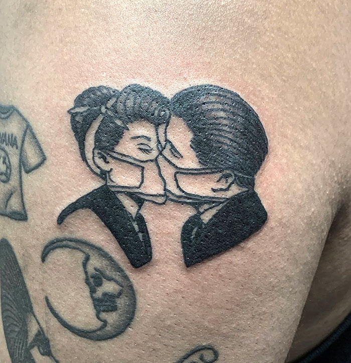 Covid-19 tattoo showing two people kissing with face masks, symbolizing love and safety during the pandemic.