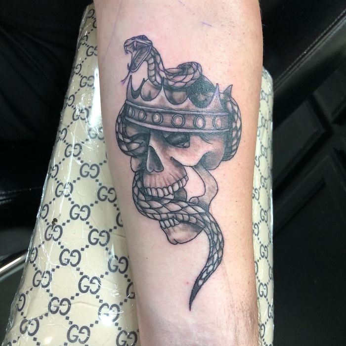 Tattoo design of a crowned skull with a snake; an overly requested design in tattoo artistry.