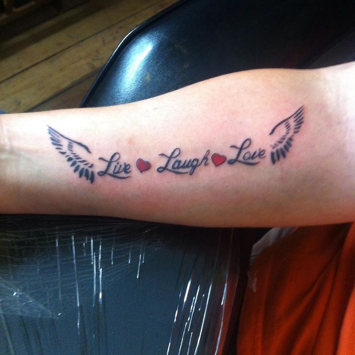 "Live Laugh Love tattoo with wings, a common design requested by tattoo enthusiasts."