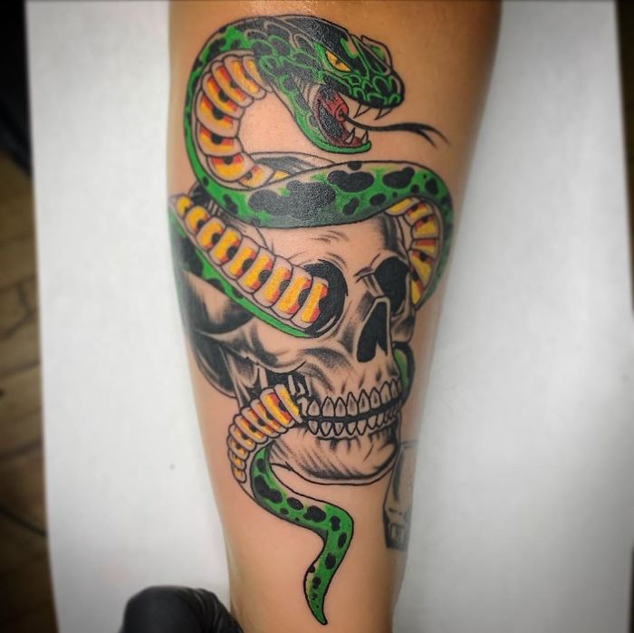 Tattoo of a snake entwined with a skull, a common design many tattoo artists frequently encounter.