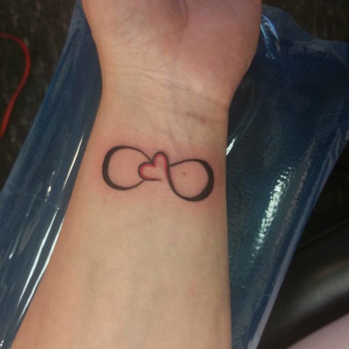 Infinity heart tattoo design on a wrist, a popular request among tattoo designs.