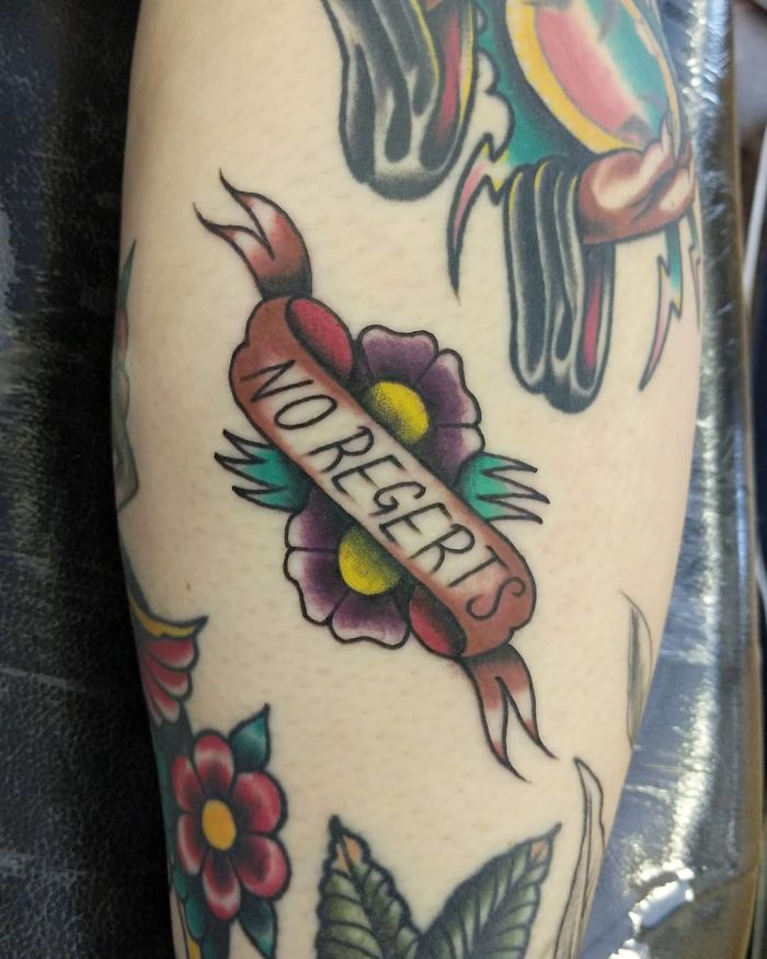 Tattoo design with a misspelled "No Regerts" banner and flowers, a commonly requested tattoo pattern.