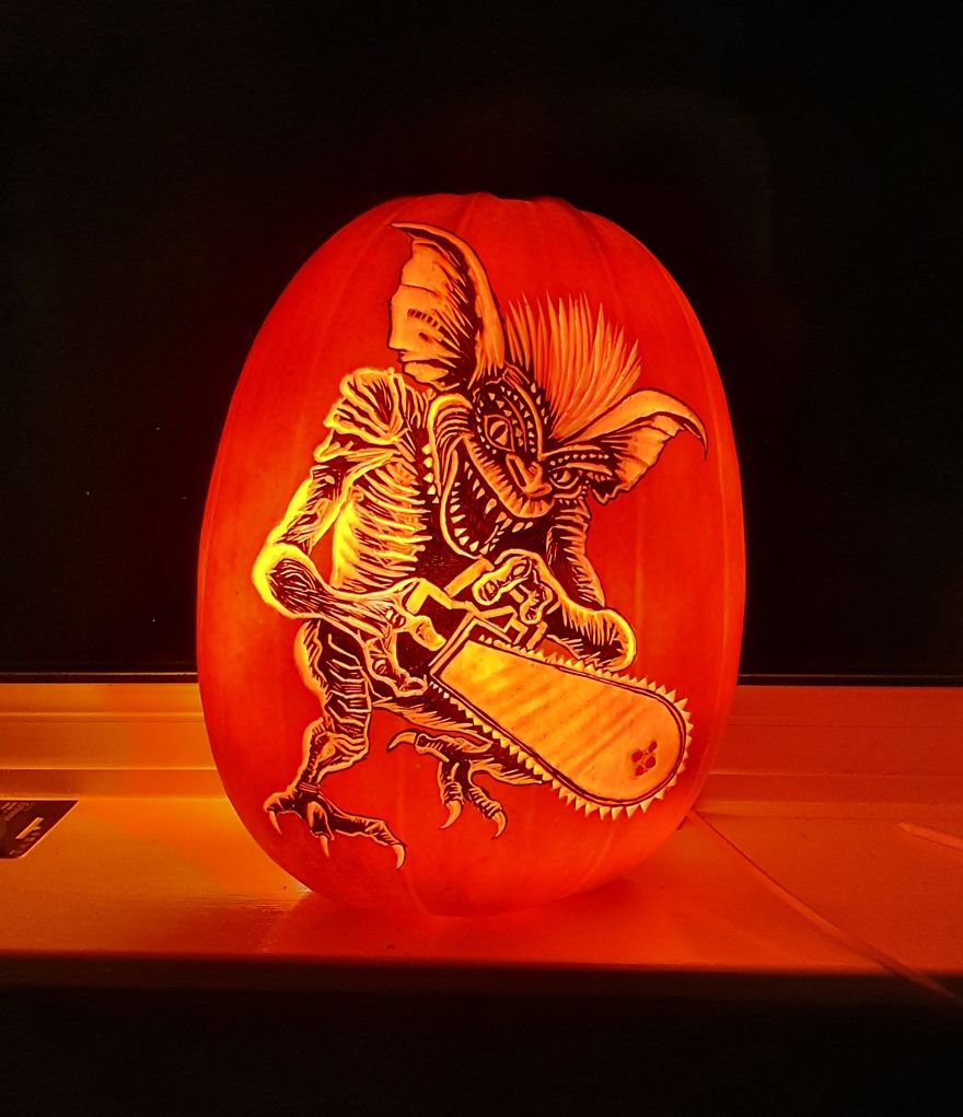 Intricately carved pumpkin with a gremlin holding a chainsaw, showcasing creative pumpkin carving skills. Intricately carved pumpkin with a gremlin holding a chainsaw, showcasing creative pumpkin carving skills.