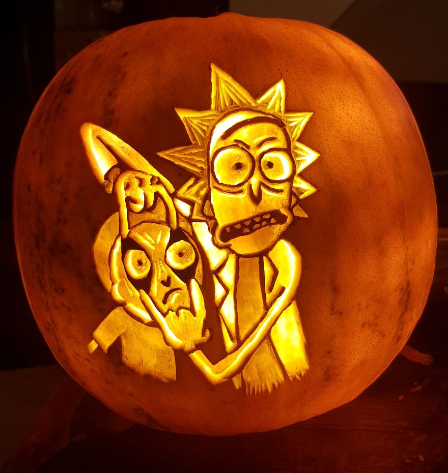 Pumpkin carving of horror scene characters, illuminated with intricate designs.