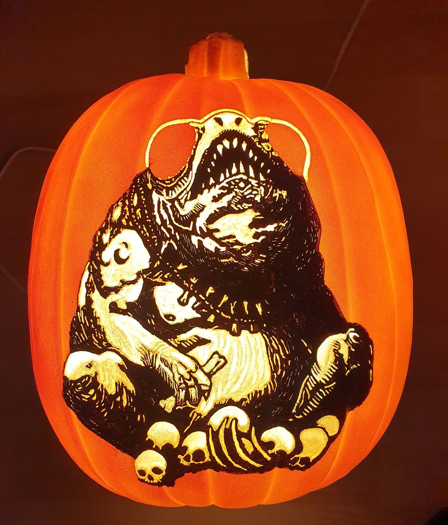 Pumpkin carving resembling a horror scene character, featuring a monstrous creature with skulls at its feet.
