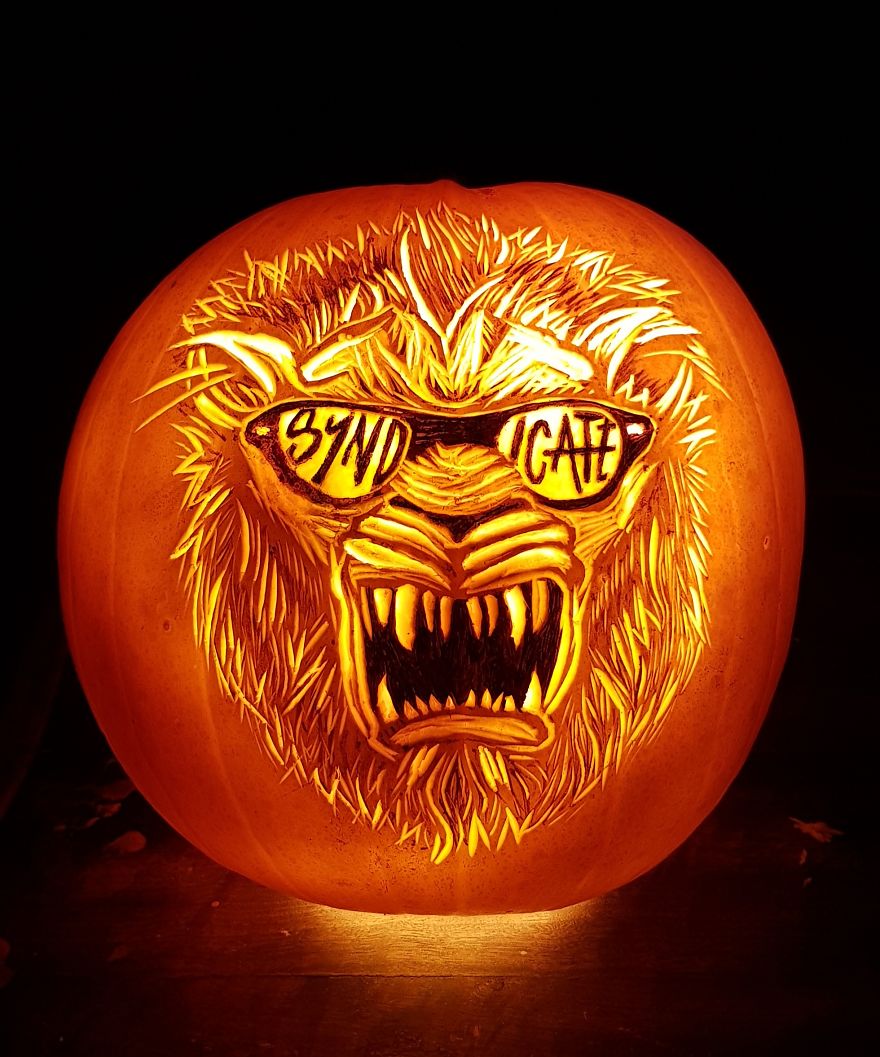 Pumpkin carving depicting a horror scene character with sharp fangs and sunglasses.