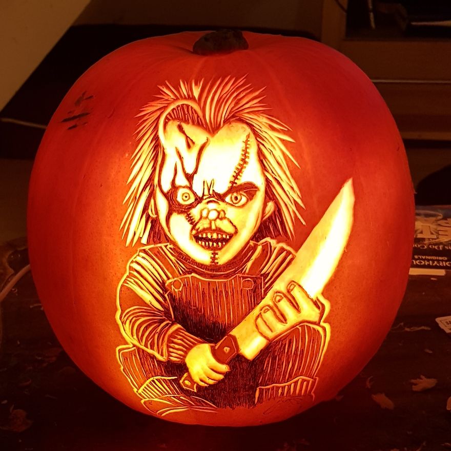 Pumpkin carving of a horror scene character with detailed facial features and a knife in hand.