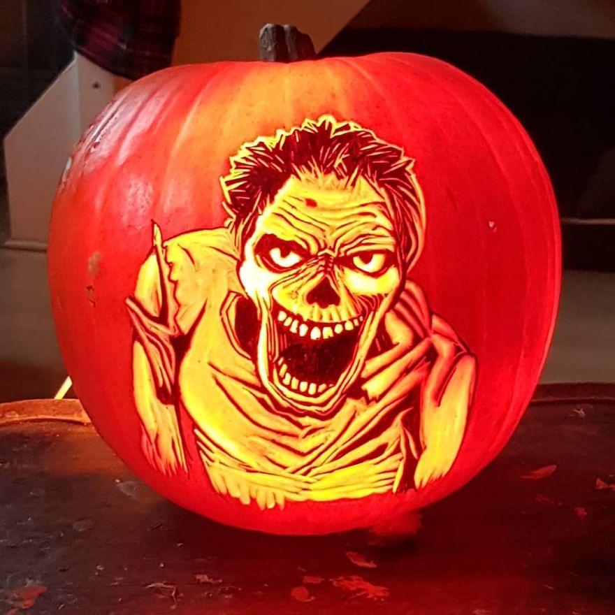 Pumpkin carving depicting a creepy horror scene character with a menacing grin and wild hair.