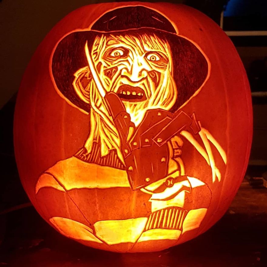 Pumpkin carving of a horror scene character with detailed features and a sinister expression.