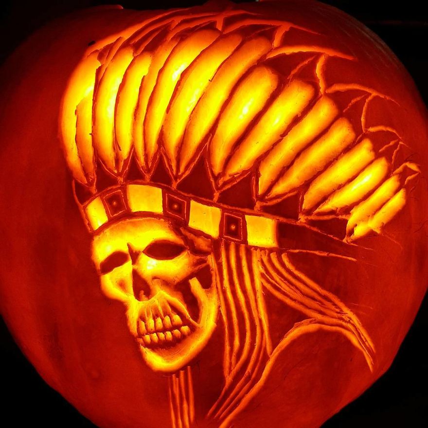 Pumpkin carving depicting a skull with a headdress, inspired by horror scene characters.