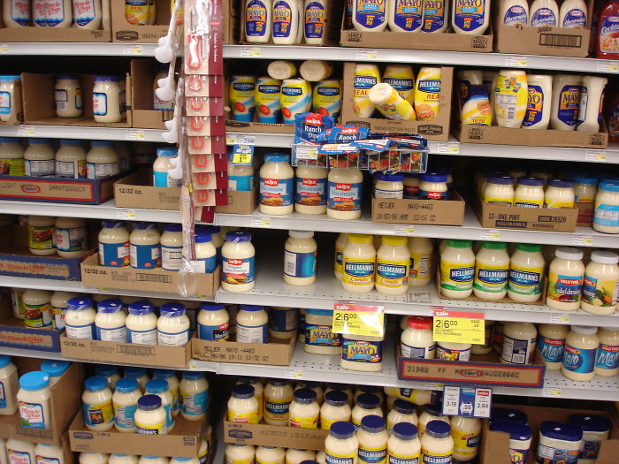 Grocery store shelves stocked with various brands of mayonnaise illustrating funny stories about stupid moments.