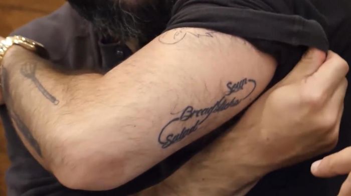 Arm displaying tattoo design with cursive script, a common choice among overly requested tattoos.
