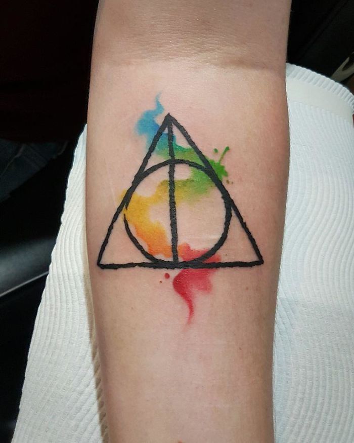 Colorful minimalist tattoo design with geometric shapes and watercolor accents.