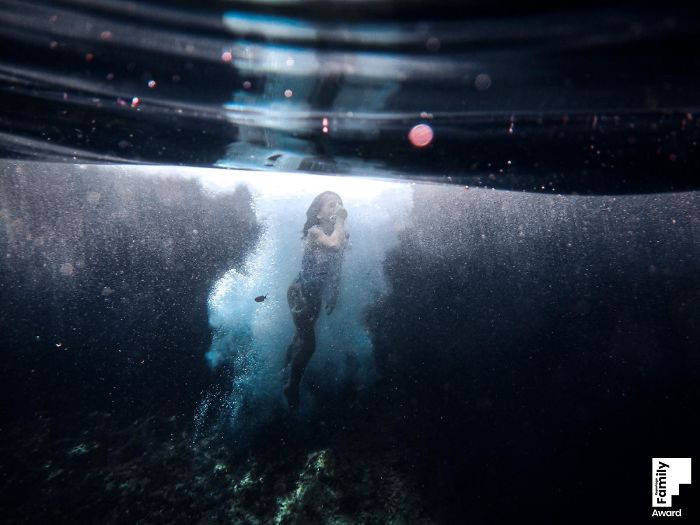 Underwater photo capturing a family moment with bubbles and light rays, showcasing the art of family photography.