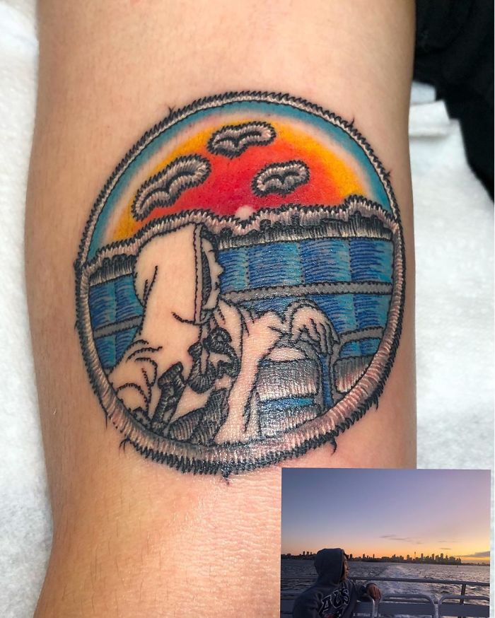 Tattoo of a sewn-on patch design with a sunset scene and figure on a person's arm, highlighting tattoo art style.