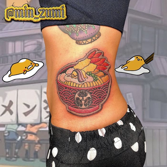 Sewn-on patch tattoo of a noodle bowl on a person's side, with cartoon eggs in the background.