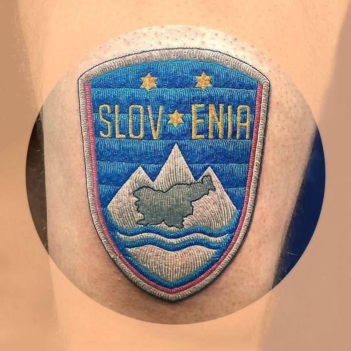 Tattoo resembling a sewn-on patch of a Slovenia emblem with mountains and stars.