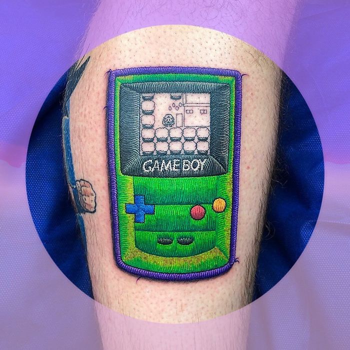 Tattoos resembling sewn-on patches, featuring a green Game Boy design on an arm.